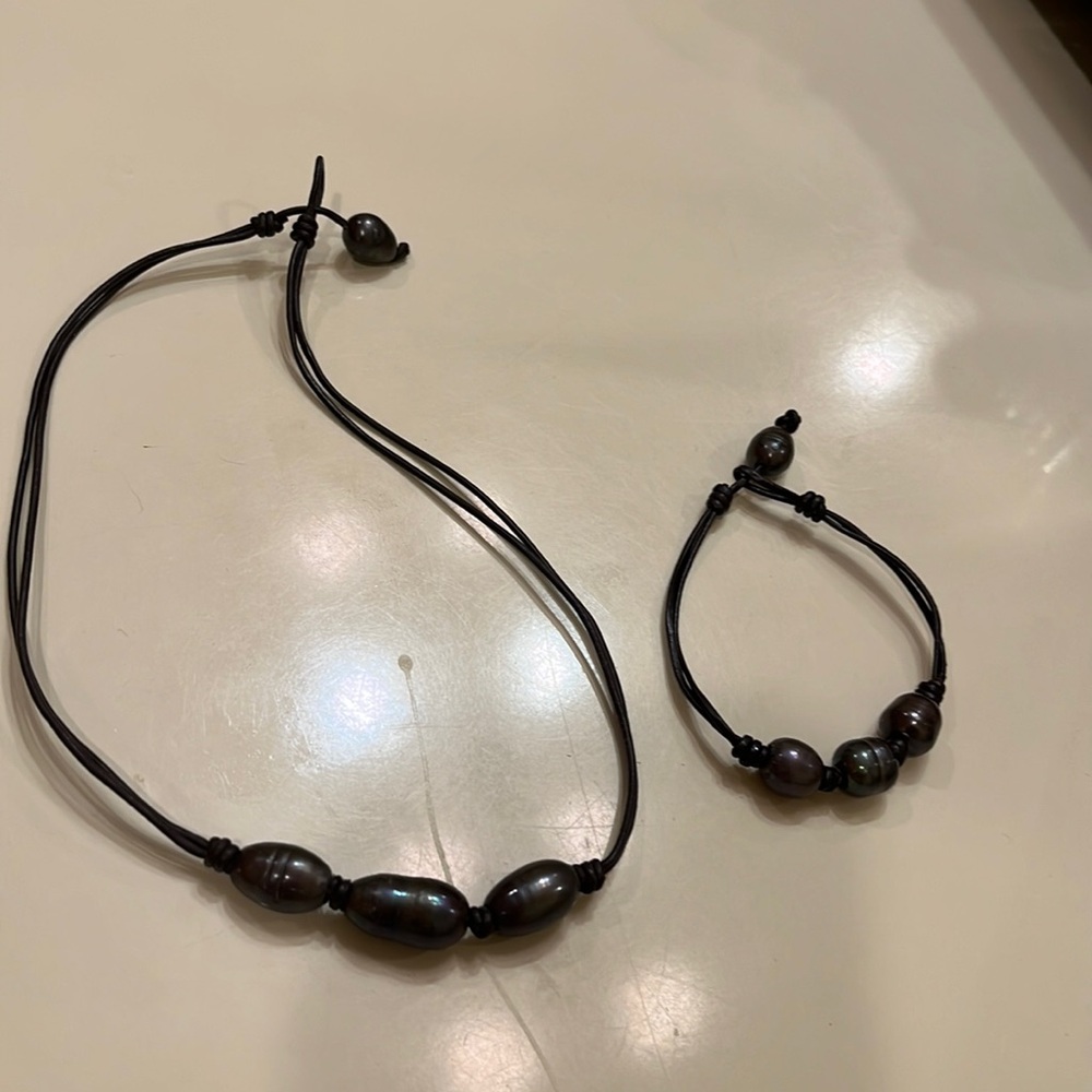 Matching black pearl bracelet and necklace with leather.
